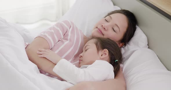 Mother and daughter are sleeping on the bed 1