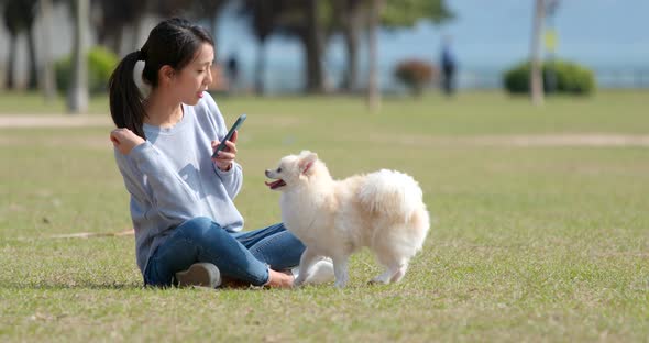 Asian Woman playing with her dog at outdoor park alt