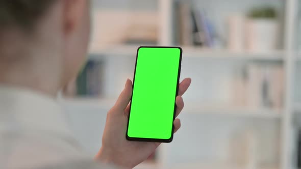 Rear View of Woman Using Smartphone with Chroma Key Screen  alt