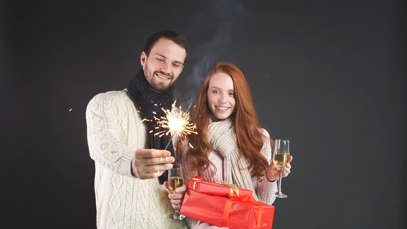 Happy Young Family Holding Champagne Glasses and Sparklers for New Year alt