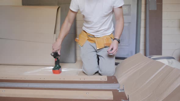 A Worker Builds a Bed in the Bedroom