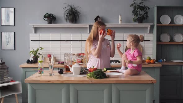 Beautiful Mother Cooking Dinner on Kitchen with Little Kid