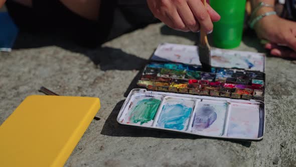 Artist is Using Aquarelle for Painting Picture Taking Blue Color By Brush alt