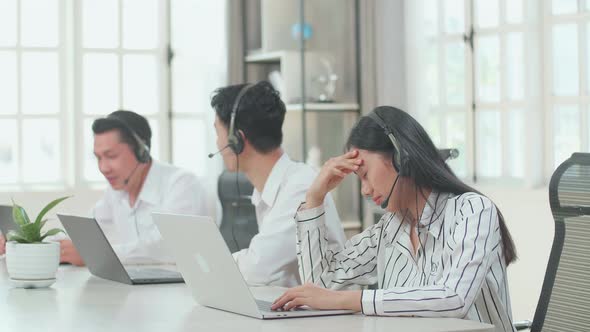 A Woman Call Centre Agents Headache Because Her Colleagues Are Talking With Each Other alt