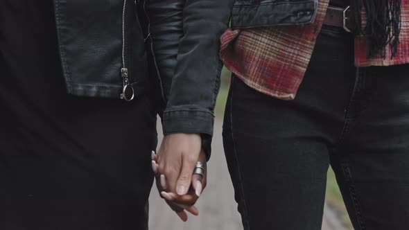 Close Up of Lesbian Couple Holding Hands and Walking alt