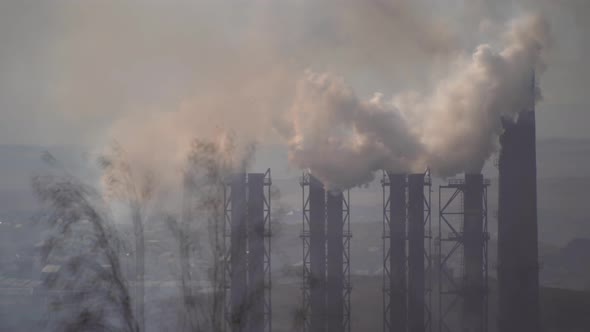 large amount of smoke and soot is emitted from the factory pipes of the metallurgical plant alt