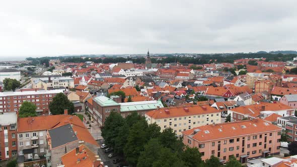 Colorful city of Ystad with red rooftops and church tower, aerial drone view alt