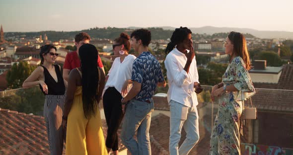 Young students talking during a party at sunset