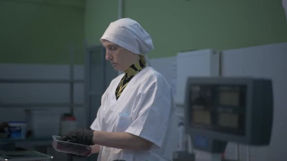 Female Worker in Black Proective Gloves Prepares Fresh Meat for Delivery to Stores alt