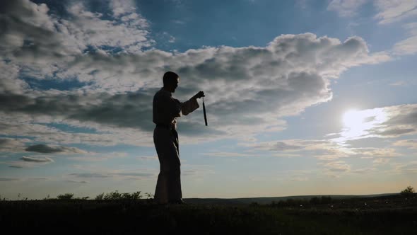 a Fighter of Martial Arts in Kimono with Nunchaku alt