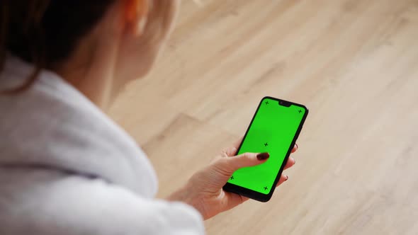 Young Female Using Smart Phone Sitting On Sofa At Home.