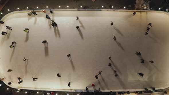 People Are Skating on Ice Rink in the Evening, Aerial Vertical Top-down View
