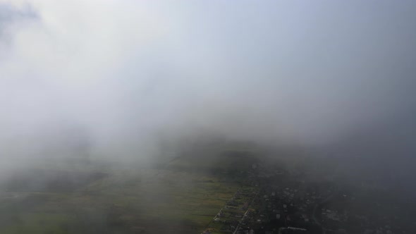 Aerial View From High Altitude of Distant City Covered with Puffy Cumulus Clouds Forming Before alt