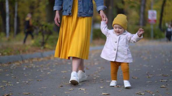 Pretty Child Daughter Walking With Mom in Park alt
