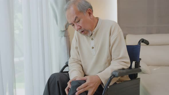 Asian Senior Elderly disabled man sit on wheelchair, suffering from injured leg at nursing home. alt