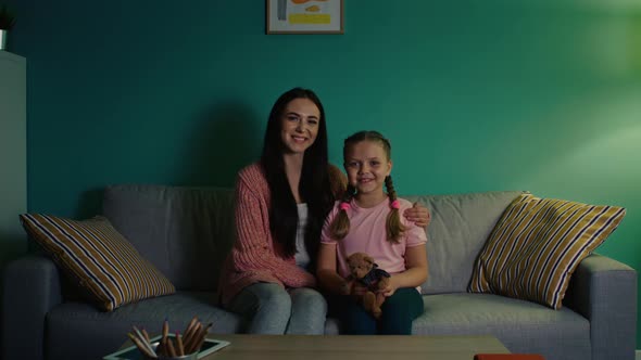 Portrait of Small Girl and Young Woman Sitting on Sofa alt