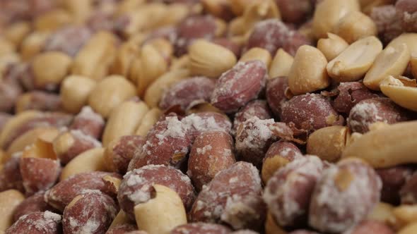 Arachis hypogaea snack slow pan 4K 2160p 30fps UltraHD footage - Pile of roasted peanuts on white ba alt