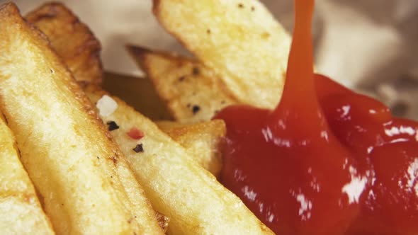 Slow Motion Pouring Ketchup on French Fries Close Up