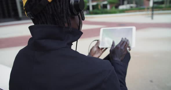 African American Man Works with Tablet Computer Urban Park Flips Through Feed on Social Networks alt