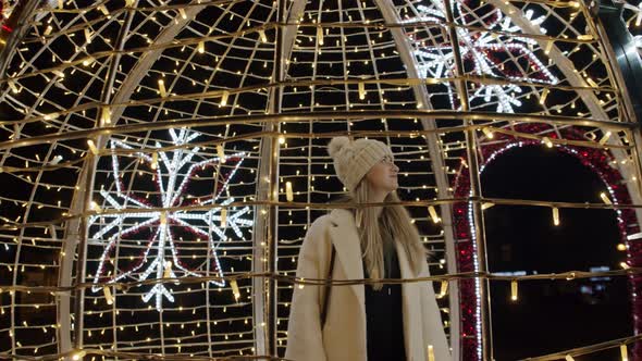 Woman in Winter Outfit Looking at Christmas Lights