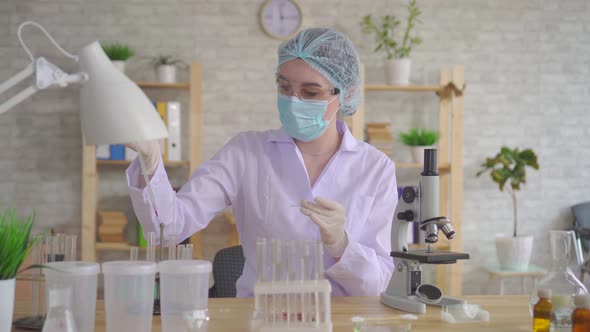 Close Up Woman Laboratory Technician Conducts Research Using a Microscope alt