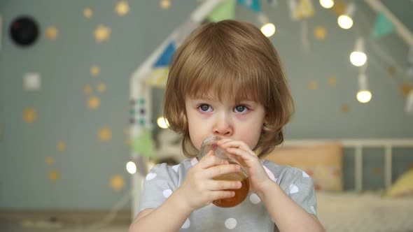 Girl Drinks Apple Juice From Bottle and Spills It on Tshirt alt