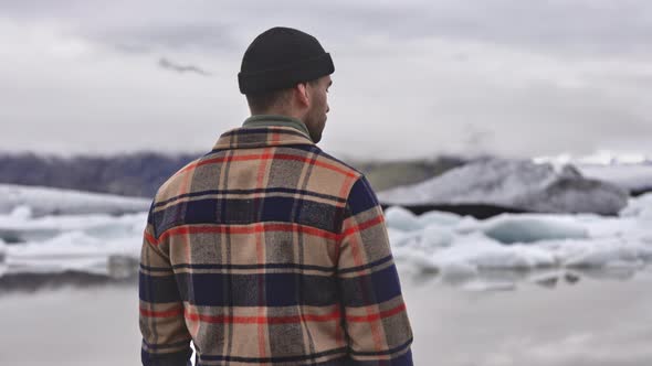 Clear Skies Frozen Lake and Melting Glacier with Male Tourist in Foreground alt
