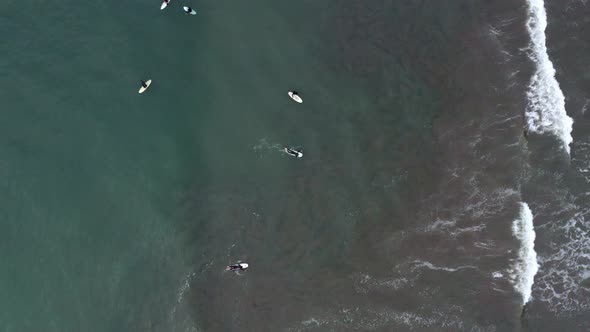 AERIAL: drone, surfers riding the waves, ascending view alt