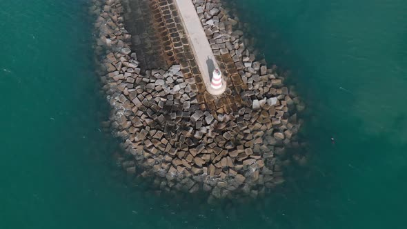 Famous Lighthouse on Port of Portimao Pier in Portugal - Aerial Orbit alt