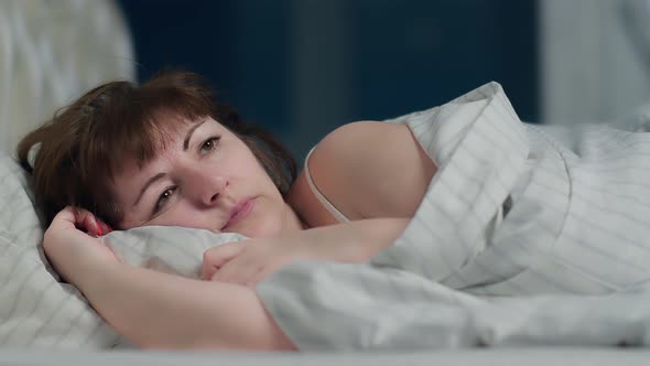 Woman Cannot Sleep Because of the Noise Covered Her Ear with a Pillow at Night