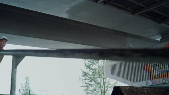 Active Teenager Practicing Jump Trick on Rail on Skate Board in Skatepark alt
