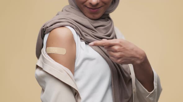 Unrecognizable Muslim Woman Demonstrating Shoulder with Medical Plaster After Vaccination and alt
