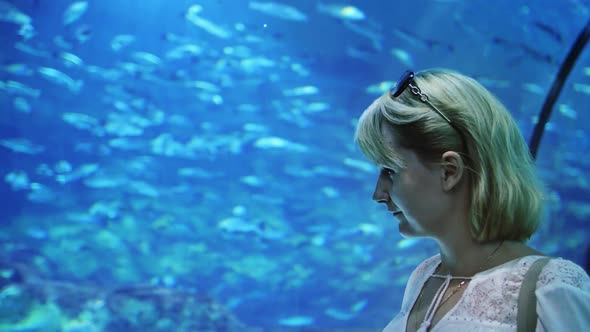 A Woman Admires the Underwater World in a Often Aquarium alt