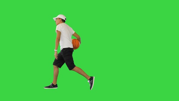 Young Casual Man Bouncing Basketball Ball on a Green Screen Chroma Key alt