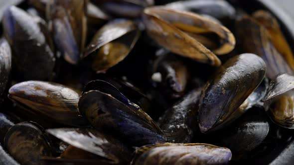 Close Up Shot of Fresh and Raw Sea Mussels in Black Ceramic Bowl Placed on Dark alt