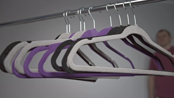Clothes Hangers a Man Removes One Hanger From a Metal Rack alt