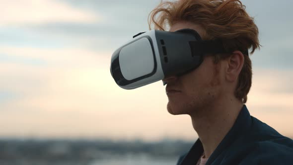 Red Haired Man Wearing VR Glasses on Fresh Air alt