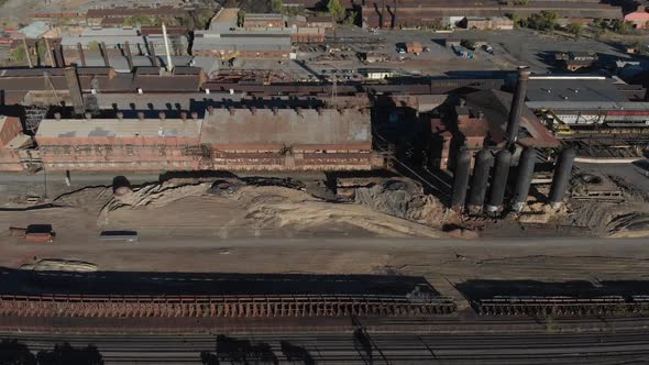 Aerial panning backward from an old steel mill slated for demolition.  Rusty, dirty, old-fashioned i alt