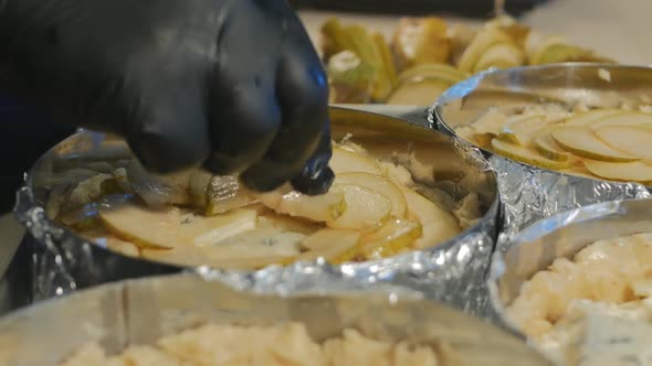 a Pastry Chef in Black Rubber Gloves Puts Pieces of Ripe Pears on the Cake Blanks