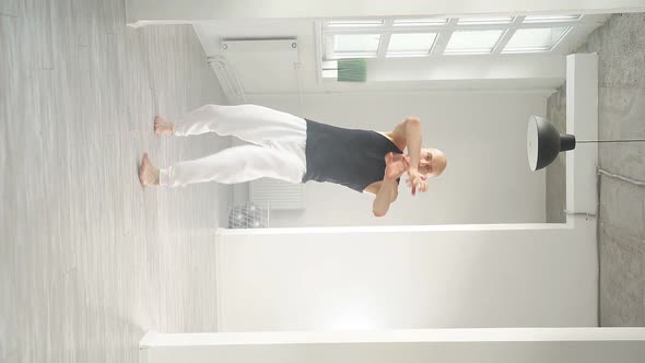 Slow Motion of a Man Performing Elements of Modern Dance in a Bright Studio