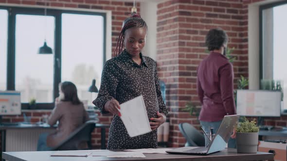 African American Woman Expecting Child and Working on Business alt