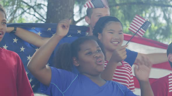 Kids watching fireworks and waving flags on Fourth of July