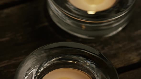 Tea candles with flaming wicks on a wooden background - CANDLES 004 alt