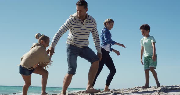 Family enjoying free time on the beach together alt