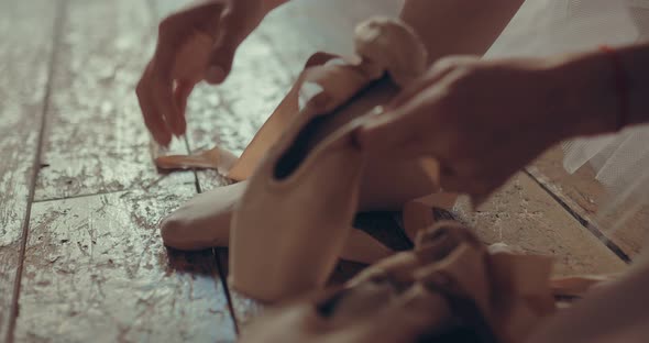 Ballerina Wearing Pointe Shoes on Her Feet Straightens the Tape alt