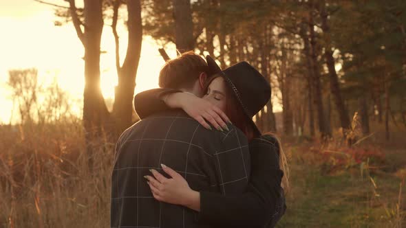 Romantic Hugs of a Young Couple on the Background of Sunset