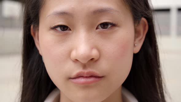 Close Up Shot of Chinese Teenage Girl Looking at Serious Camera alt