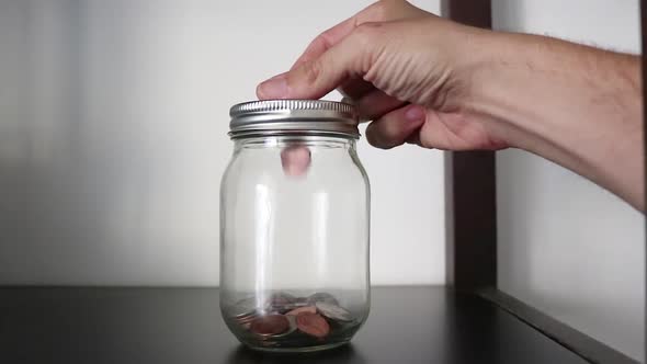 putting coins in a savings jar alt