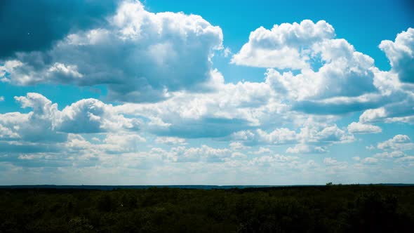 White Fluffy Clouds Slowly Float Through the Blue Daytime Sky Timelapse alt