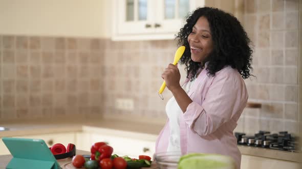 Tattooed African American Woman with Pierced Nose Dancing Singing in Cooking Spoon Having Fun at alt